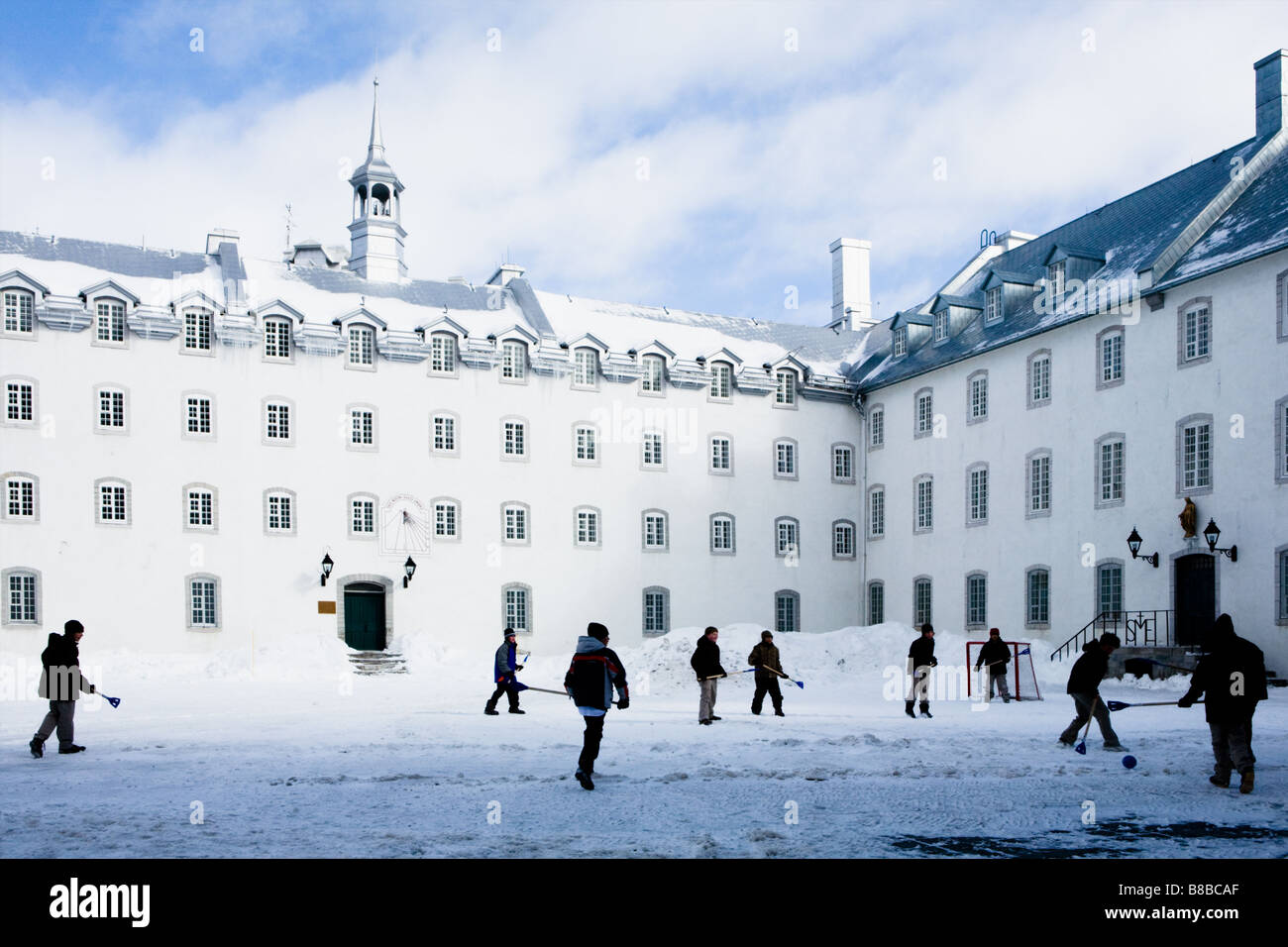 School boys playing broom hockey during recess at Seminary of Quebec City in old town Stock Photo