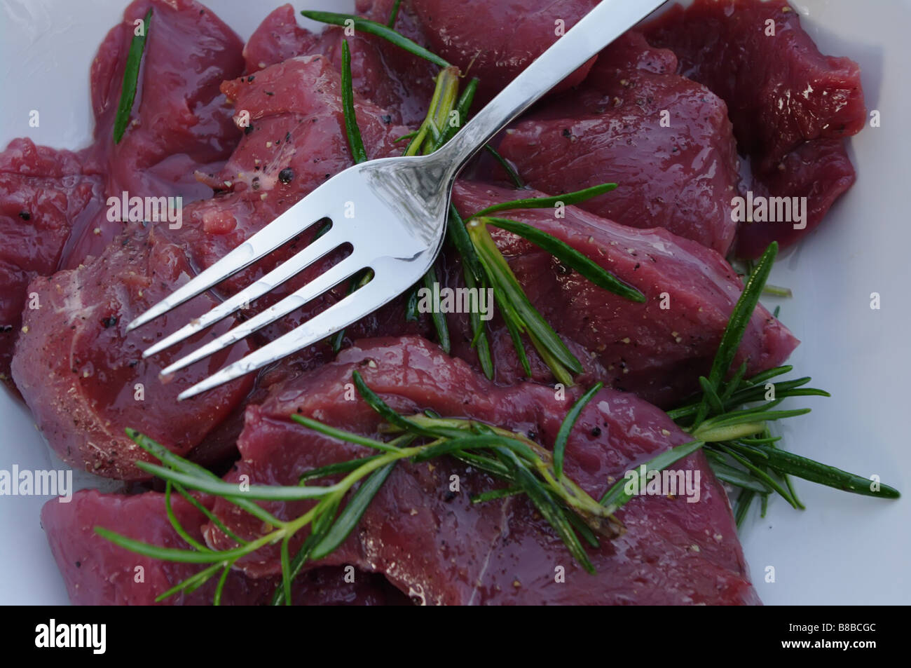 deer meat for bbq with rosemary Stock Photo Alamy