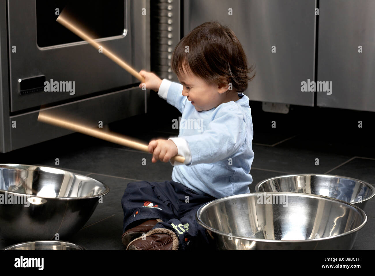 Little Boy Banging Aluminum Bowls Kitchen, Montreal, Quebec Stock Photo