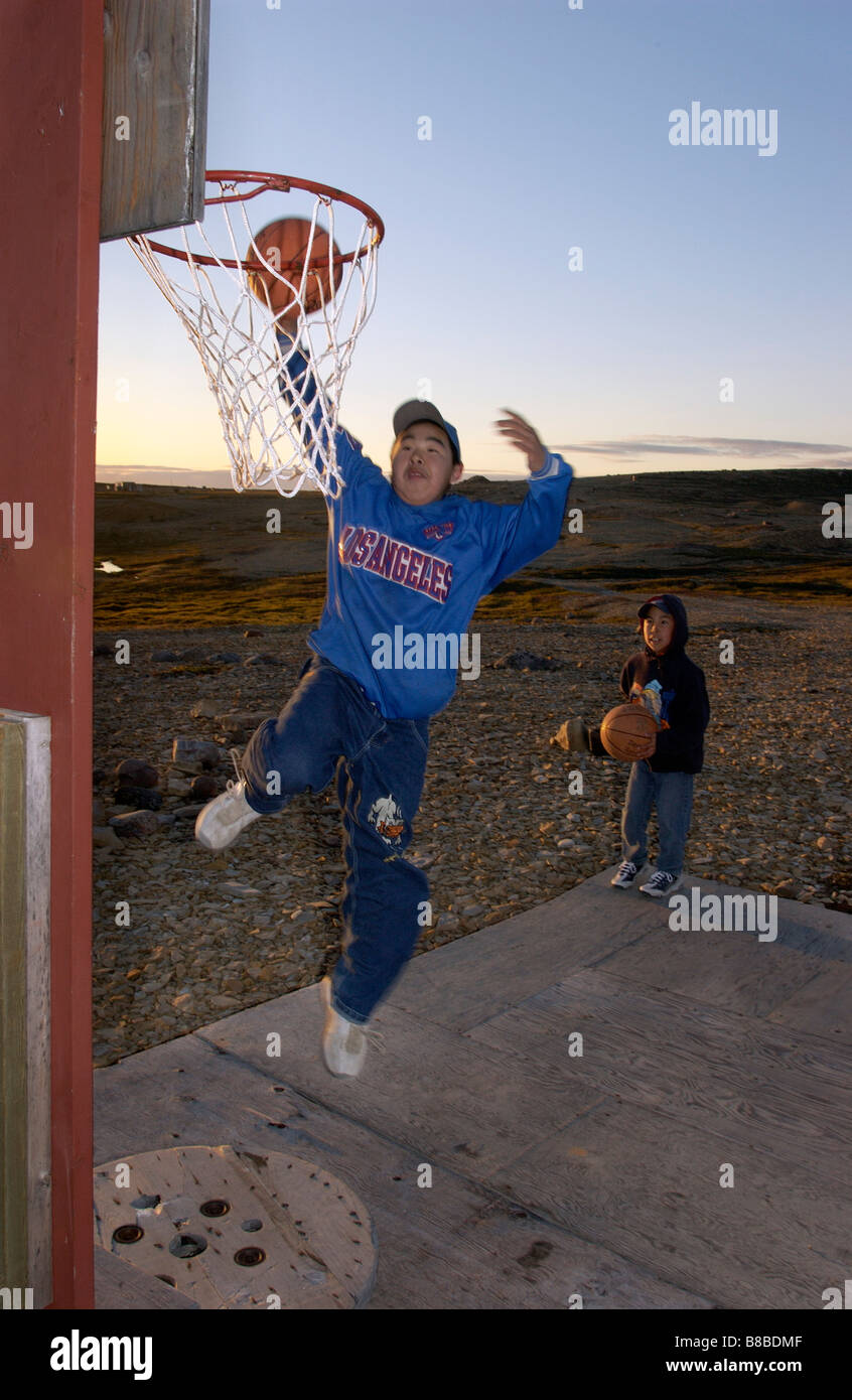 Boys Playing Basketball  Sunset, 11:00 pm, West Arm, Cambridge Bay, Nunavut Stock Photo