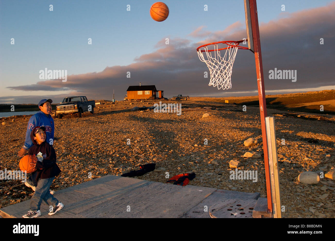 Boys Playing Basketball  Sunset, 11:00 pm, West Arm, Cambridge Bay, Nunavut Stock Photo