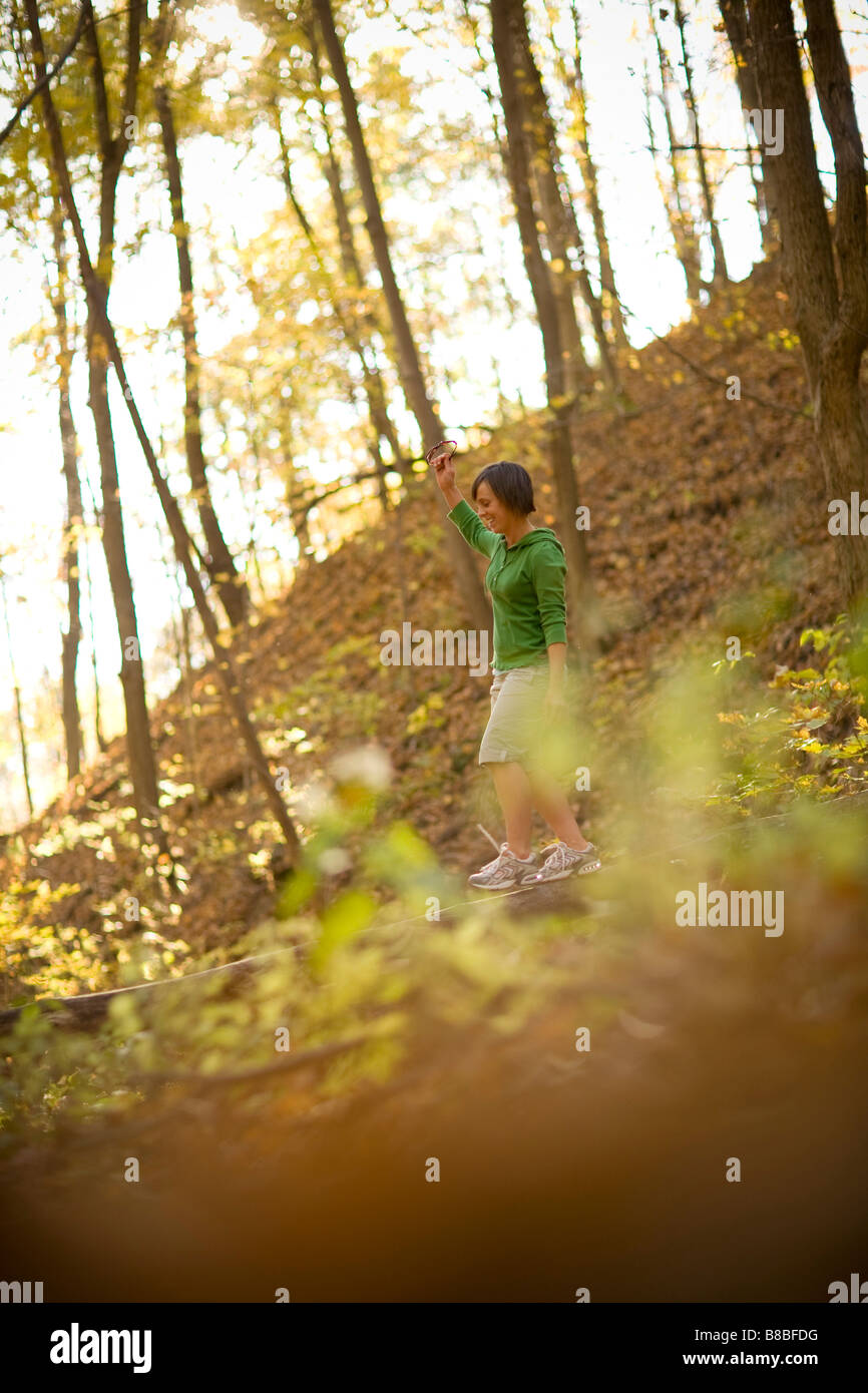 Woman balancing on fallen tree trunk in the woods Stock Photo