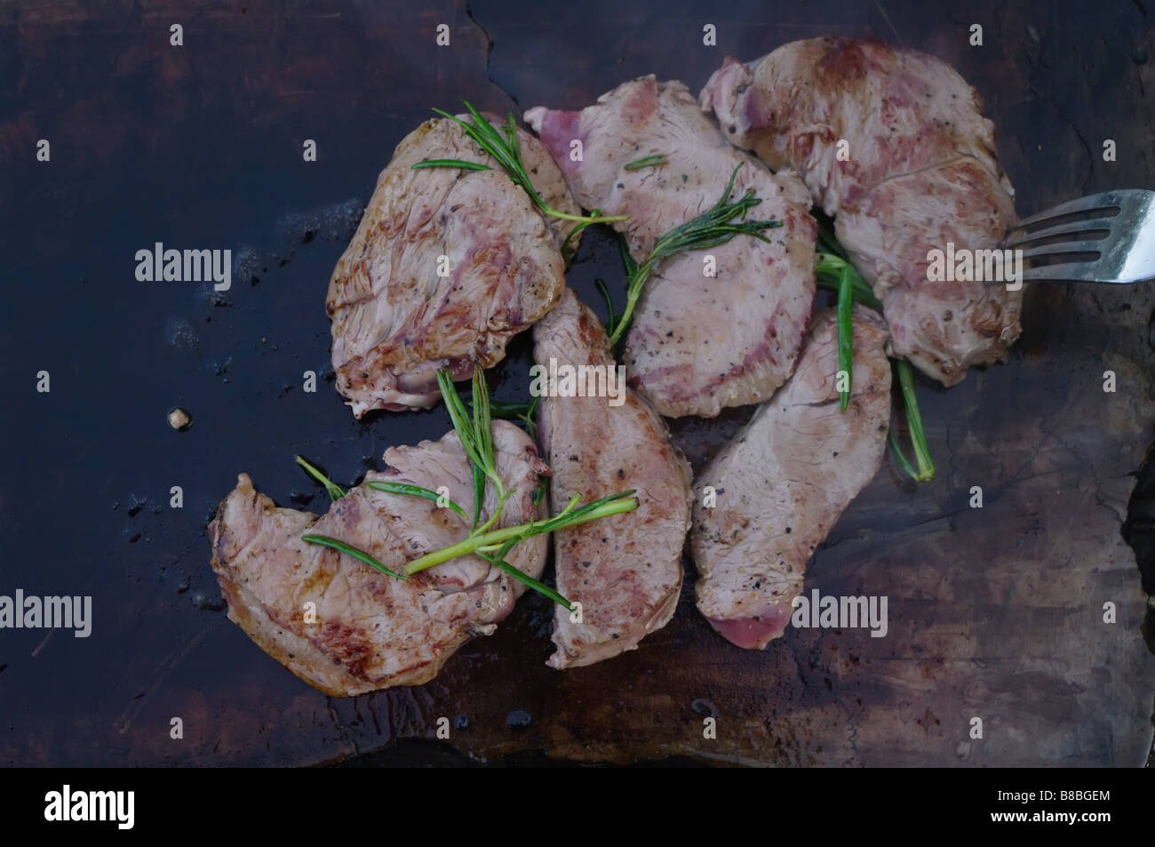 deer meat on bbq flagstone with rosemary Stock Photo Alamy