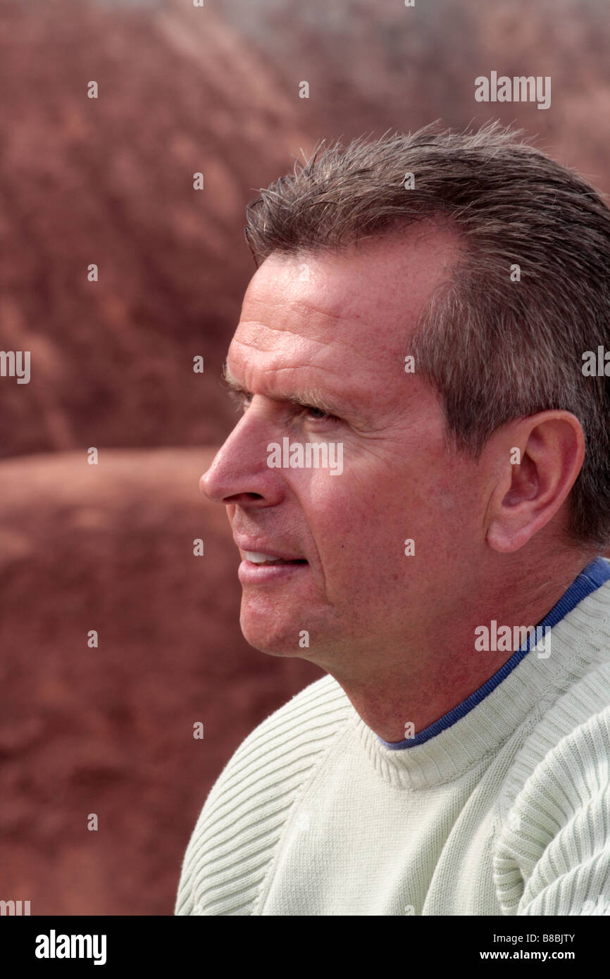 Side portrait of mature Caucasian man with red dry earth in the background Stock Photo