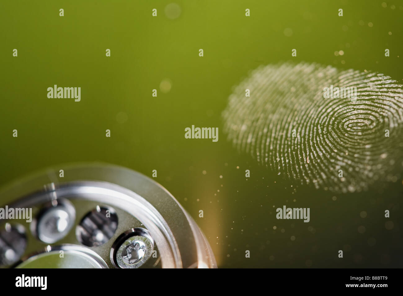 a closeup of a finger print on the shiny surface a hard disk drive Stock Photo