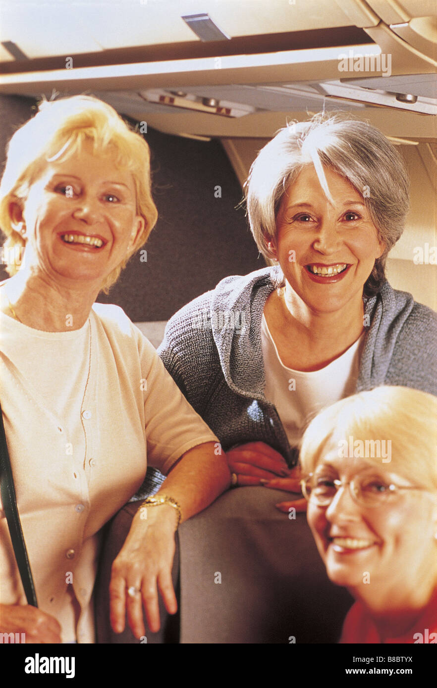 FL4784, Mad Cow Studio; Three Smiling Senior Women Airplane Stock Photo