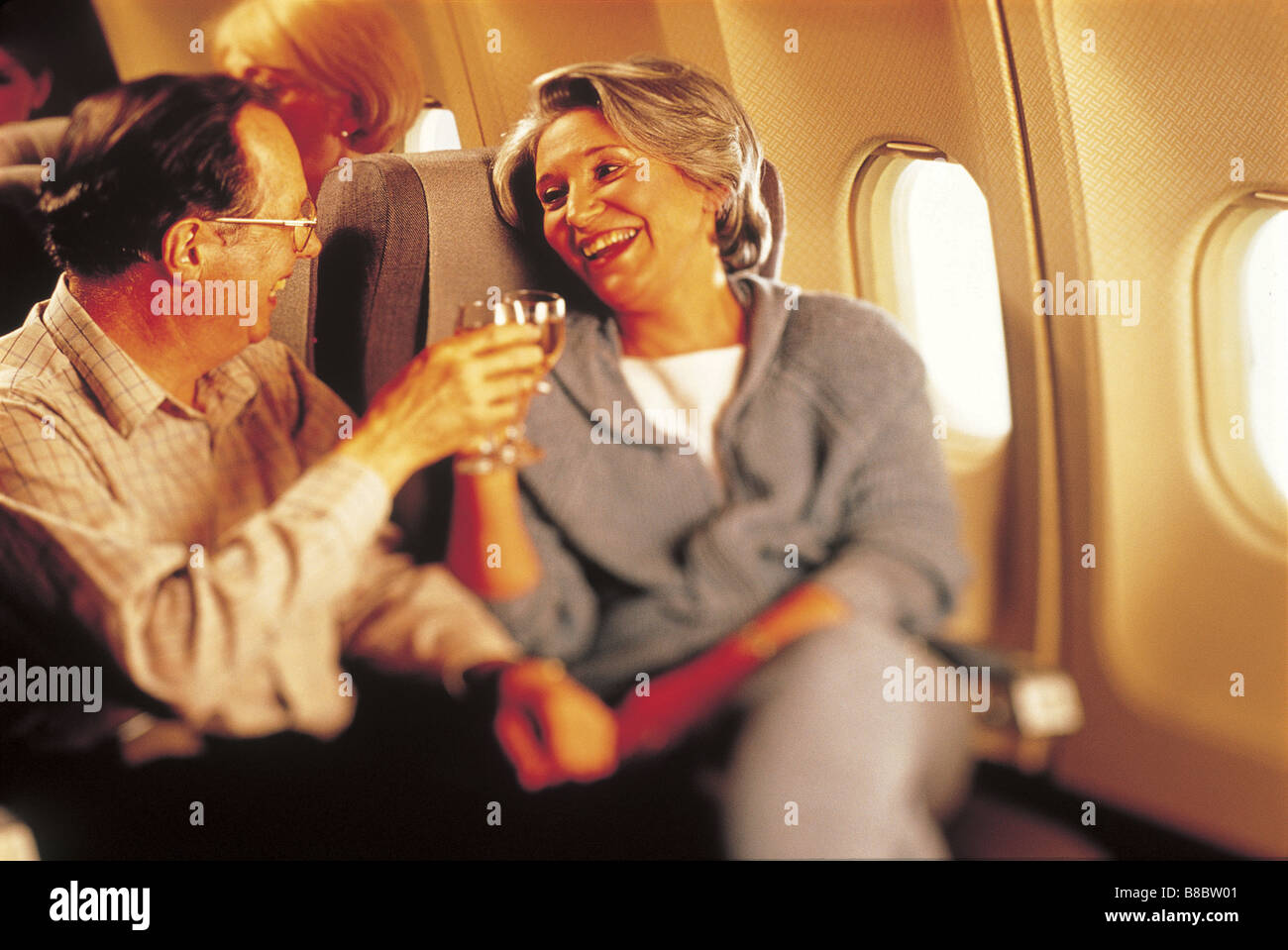 FL4788, Mad Cow Studio; Senior Couple Toasting Wine Glasses Airplane Stock Photo