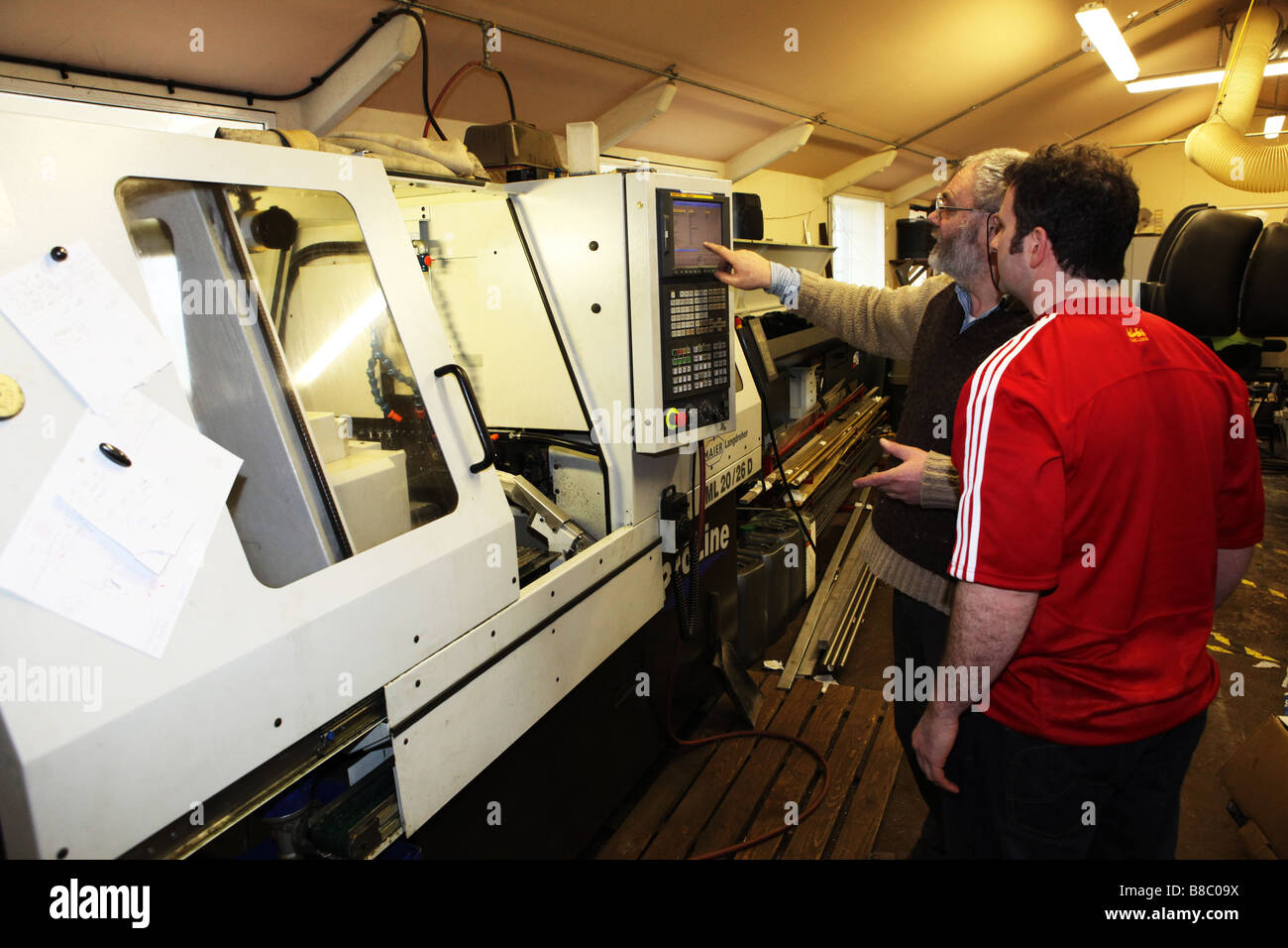 Skilled workers machine operators using a precision metal working lathe