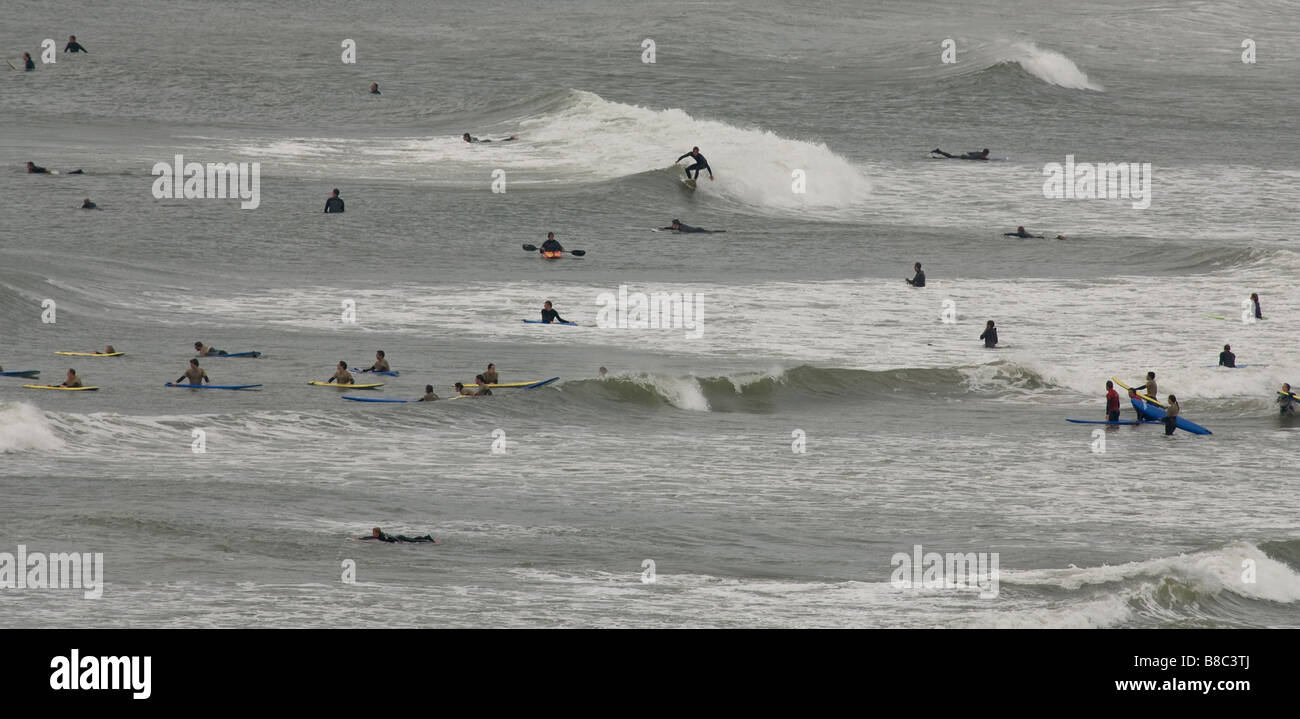 surfers in the water riding waves at croyde beach Devon Stock Photo
