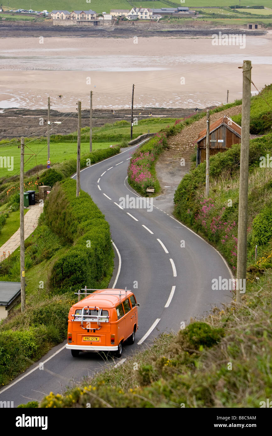 VW camper van driving down croyde road towards surf beach Stock Photo