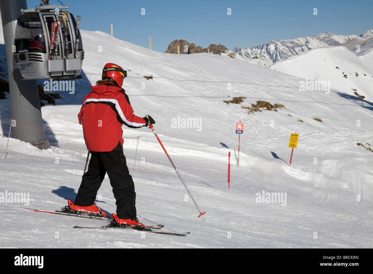 Rauris Austria EU January Skier in red white black ski jacket descending upper ski slopes from Hochalmbahn gondola station Stock Photo