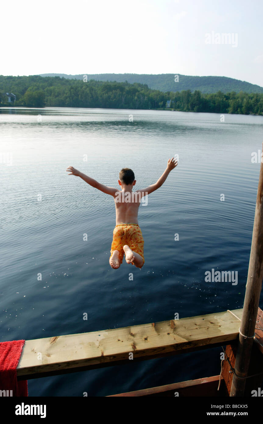 Young Boy Jumping into Lake, Lac de Neige, Quebec Stock Photo
