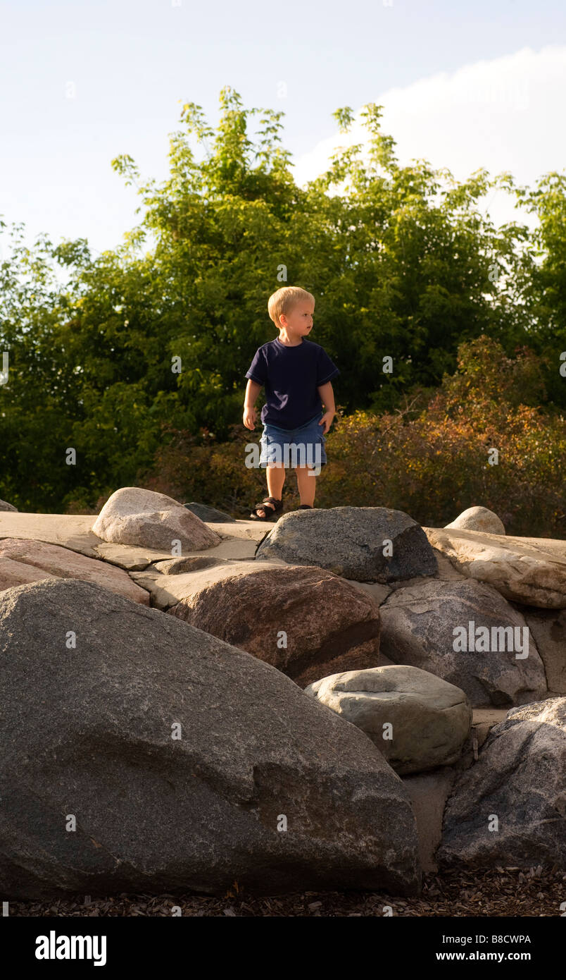 Boy standing on rocks Stock Photo - Alamy