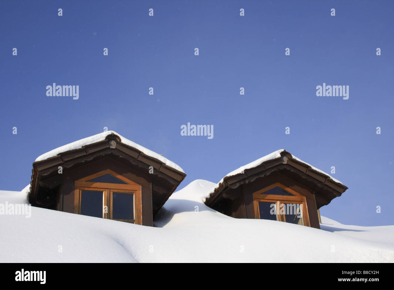 two attic windows on roof of Bavarian House, covered by snow in winter