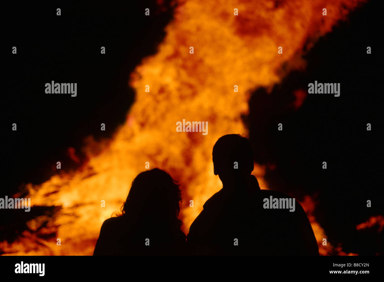 Silhouette of couple against a bonfire Stock Photo