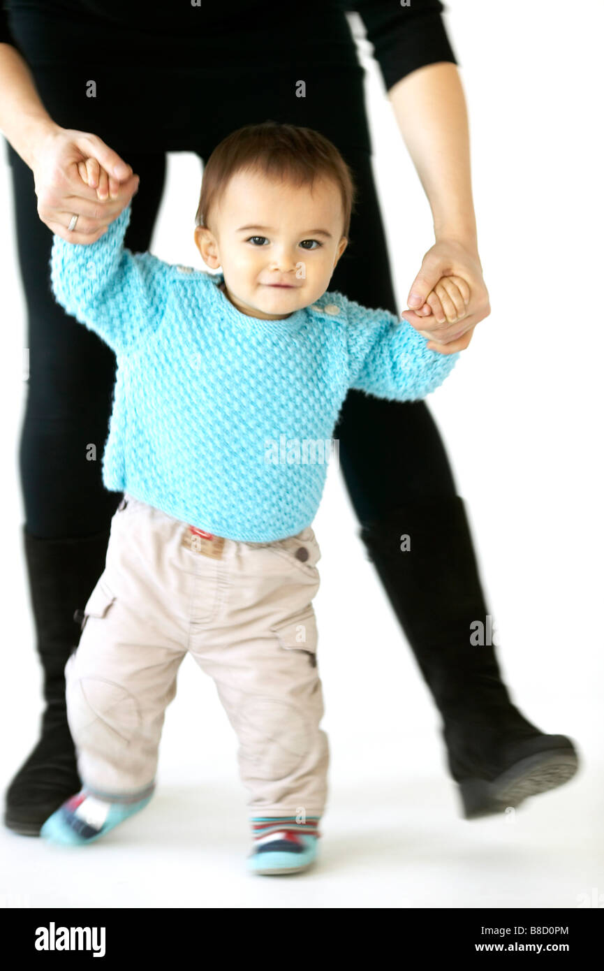 Baby Boy Walking help from an Adult Stock Photo Alamy