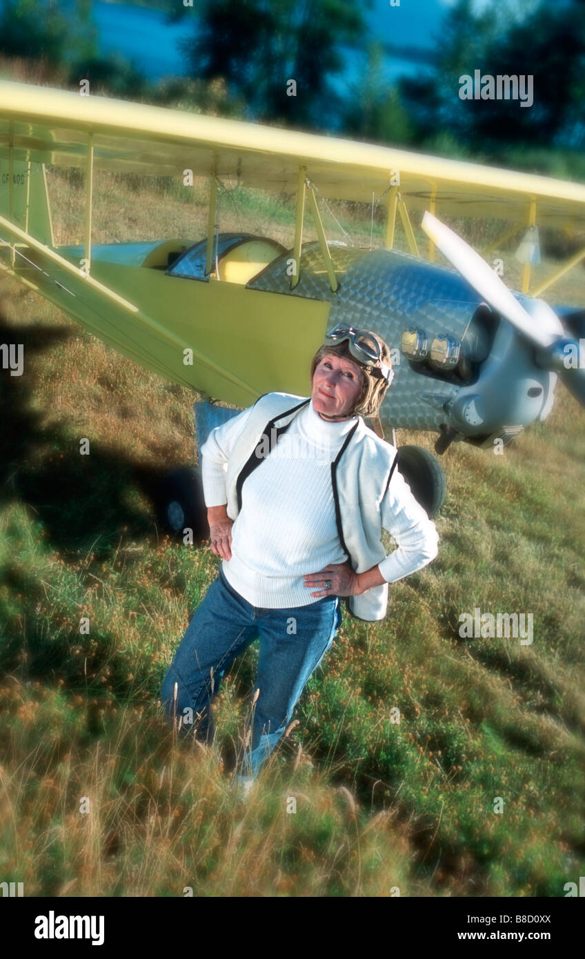 FV2574, Trevor Bonderud; Middle aged woman wearing flying goggles  hat poses proudly  her plane Stock Photo