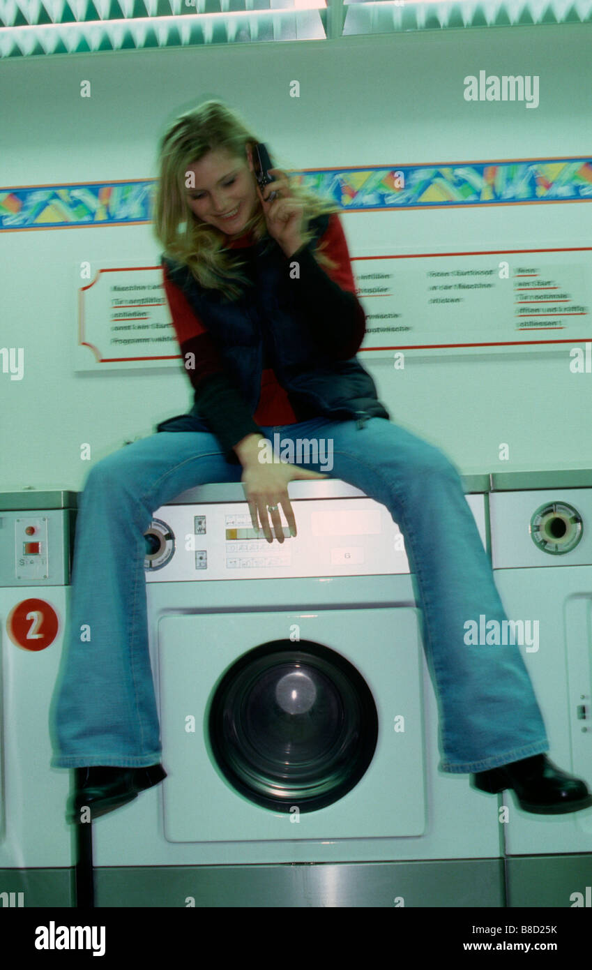 FV3051, Malek Chamoun; Young Woman Laundromat Cell Phone Stock Photo