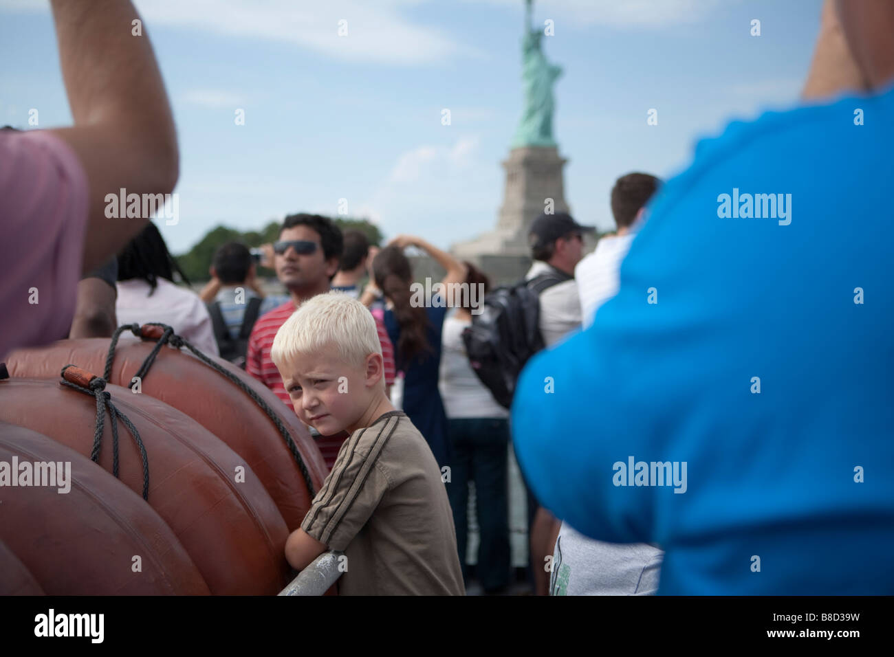 portrait of a child in a crowd near the statue of liberty Stock Photo