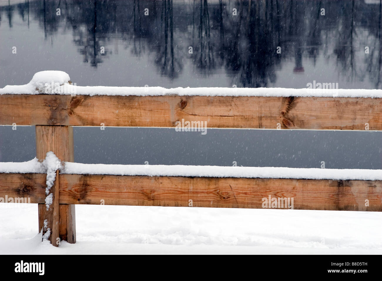 Wooden fence on not frozen winter river bank. Stock Photo