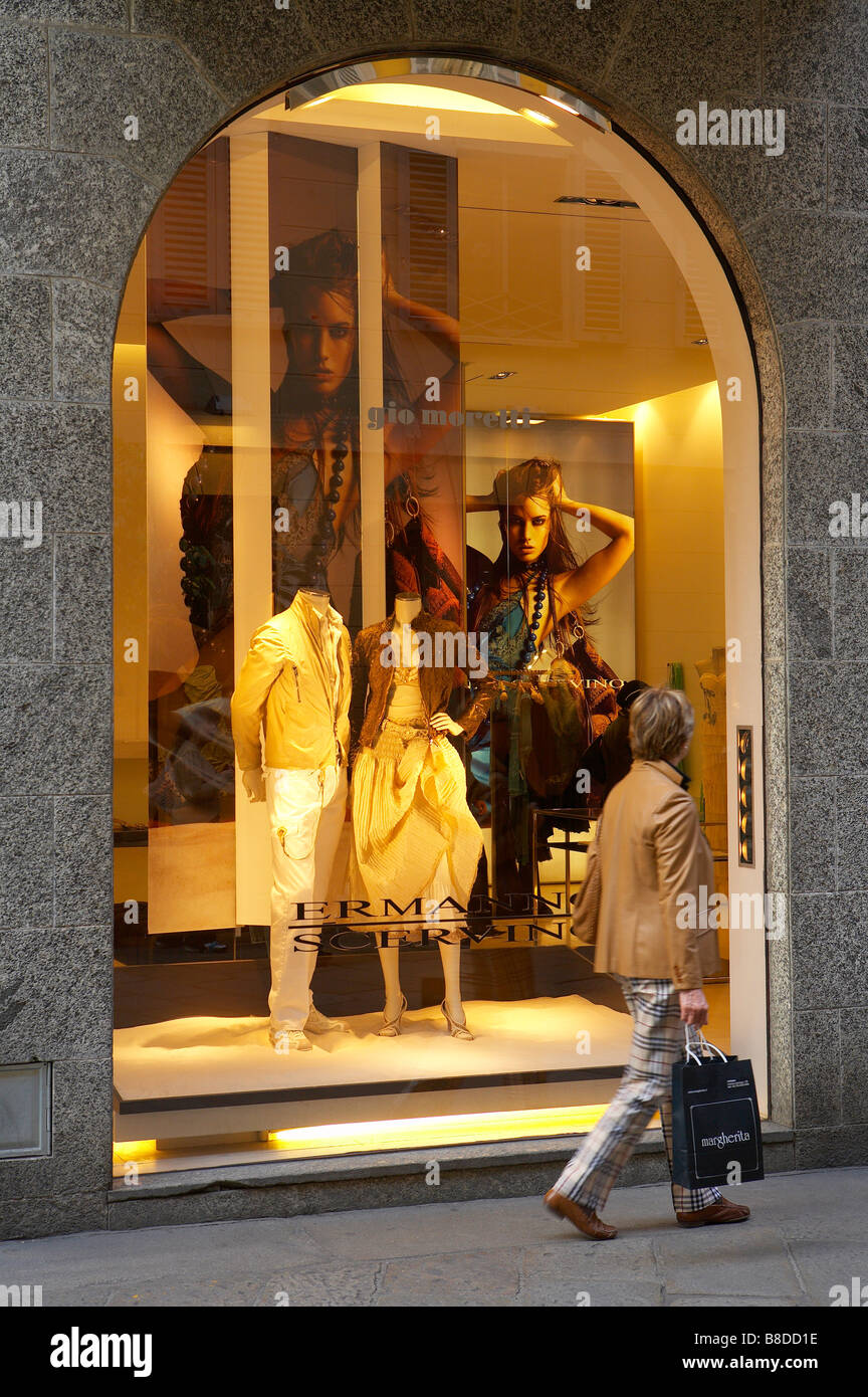 a woman looking at a display in a shop window in the fashion district, Via della Spiga, Milan, Lombardy, Italy. (NR) Stock Photo