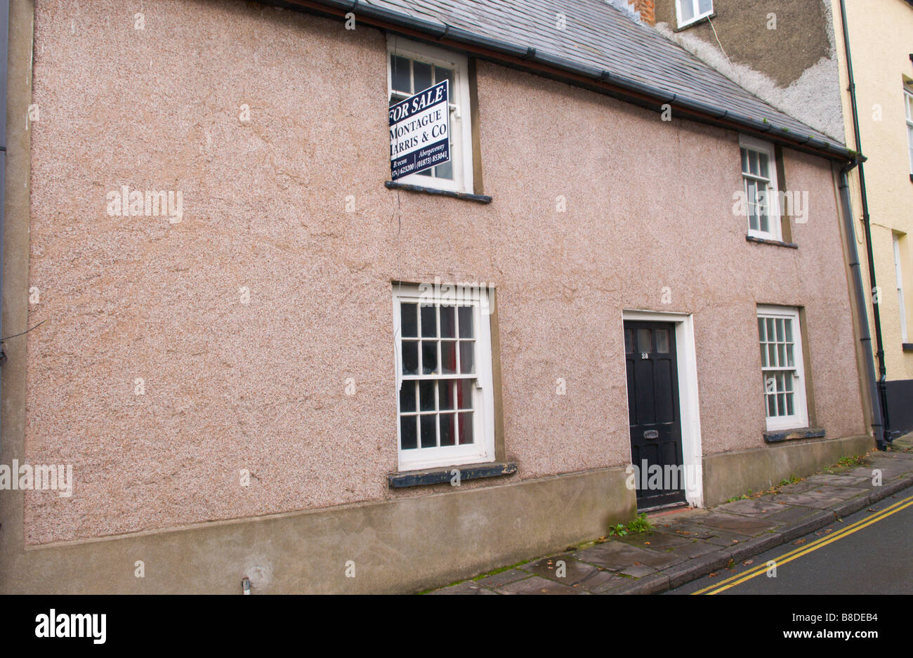 Terraced house for sale with rendered walls and sash windows in