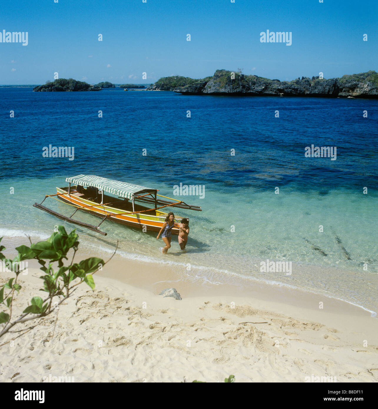 Lingayen, Philippines, The Hundred Islands,  A couple walk ashore after a splash in the sea. Stock Photo