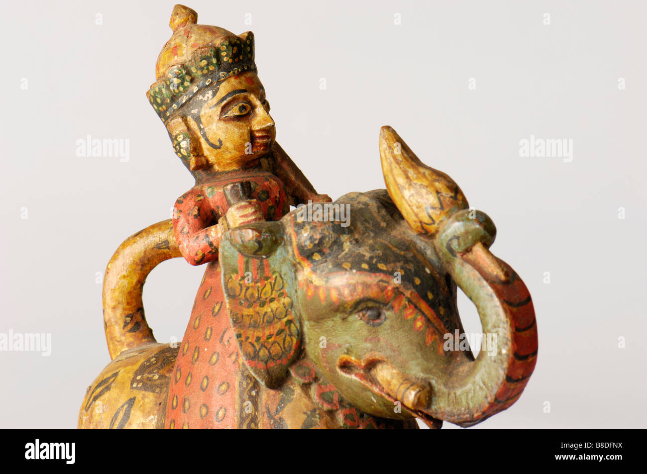 An antique Indian carved wood painted caparisoned elephant with rider. Stock Photo