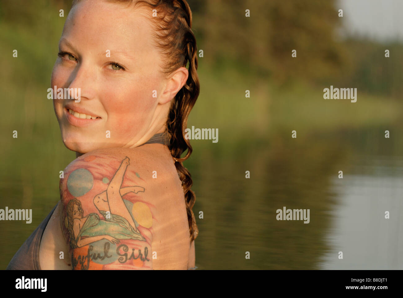 Woman with wet hair and tattoos in lake, Lake Katherine, Riding Mountain National Park, Manitoba, Canada Stock Photo