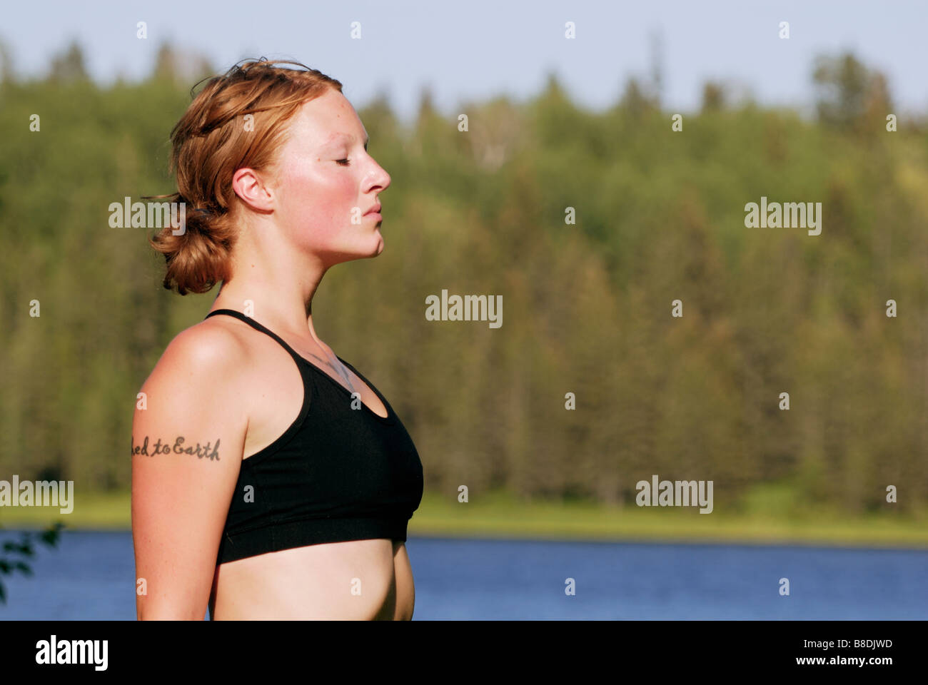 Woman in with eyes closed, beside Grayling Lake, Riding Mountain National Park, Manitoba, Canada Stock Photo