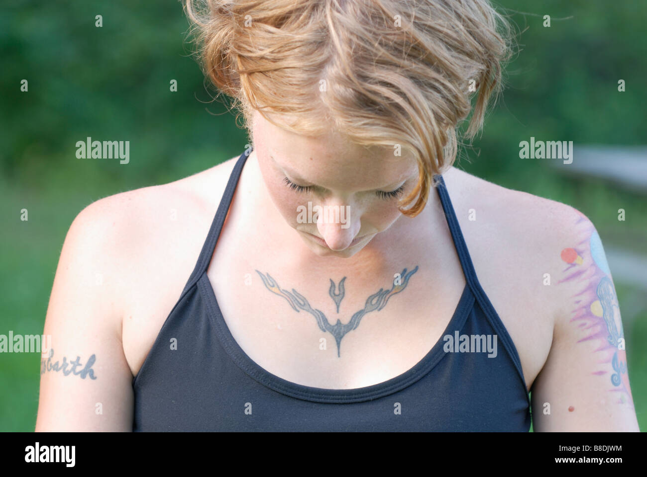 Woman with tattoos with head lowered, Grayling Lake, Riding Mountain National Park, Manitoba, Canada Stock Photo