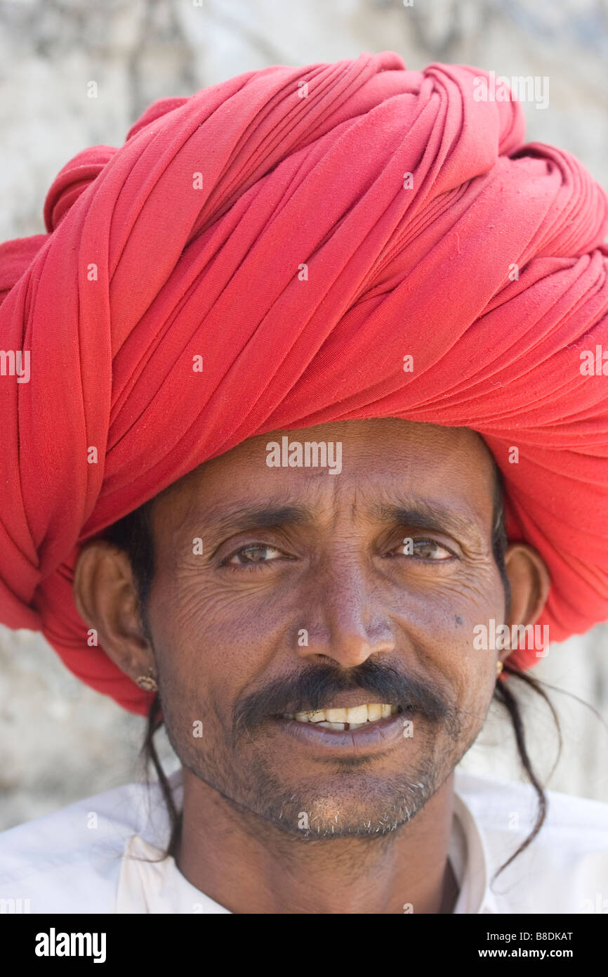 A camel owner with a red turban near Udaipur, Rajasthan India Stock Photo