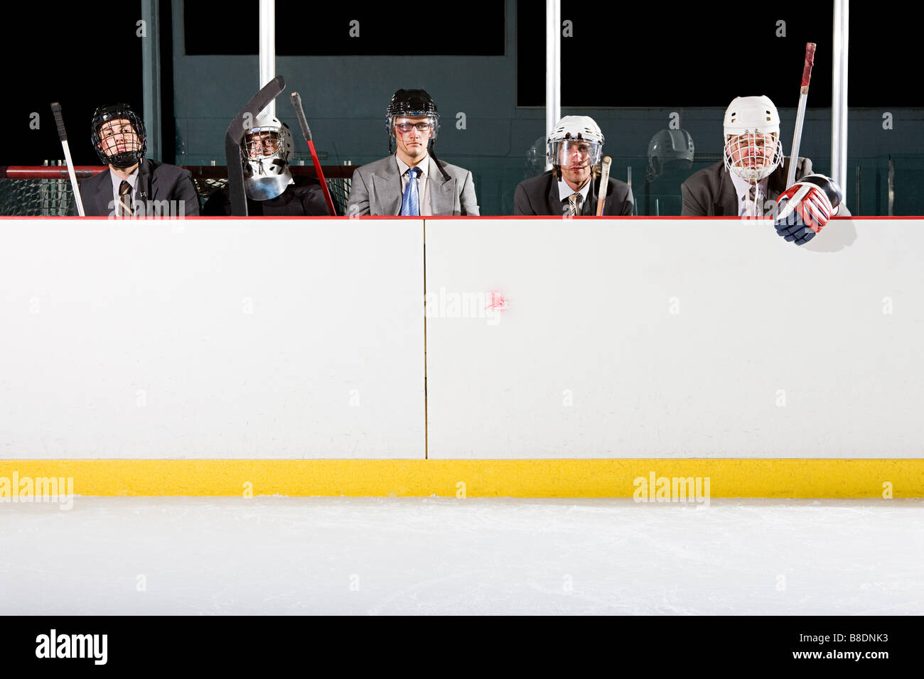 Businessmen playing ice hockey Stock Photo