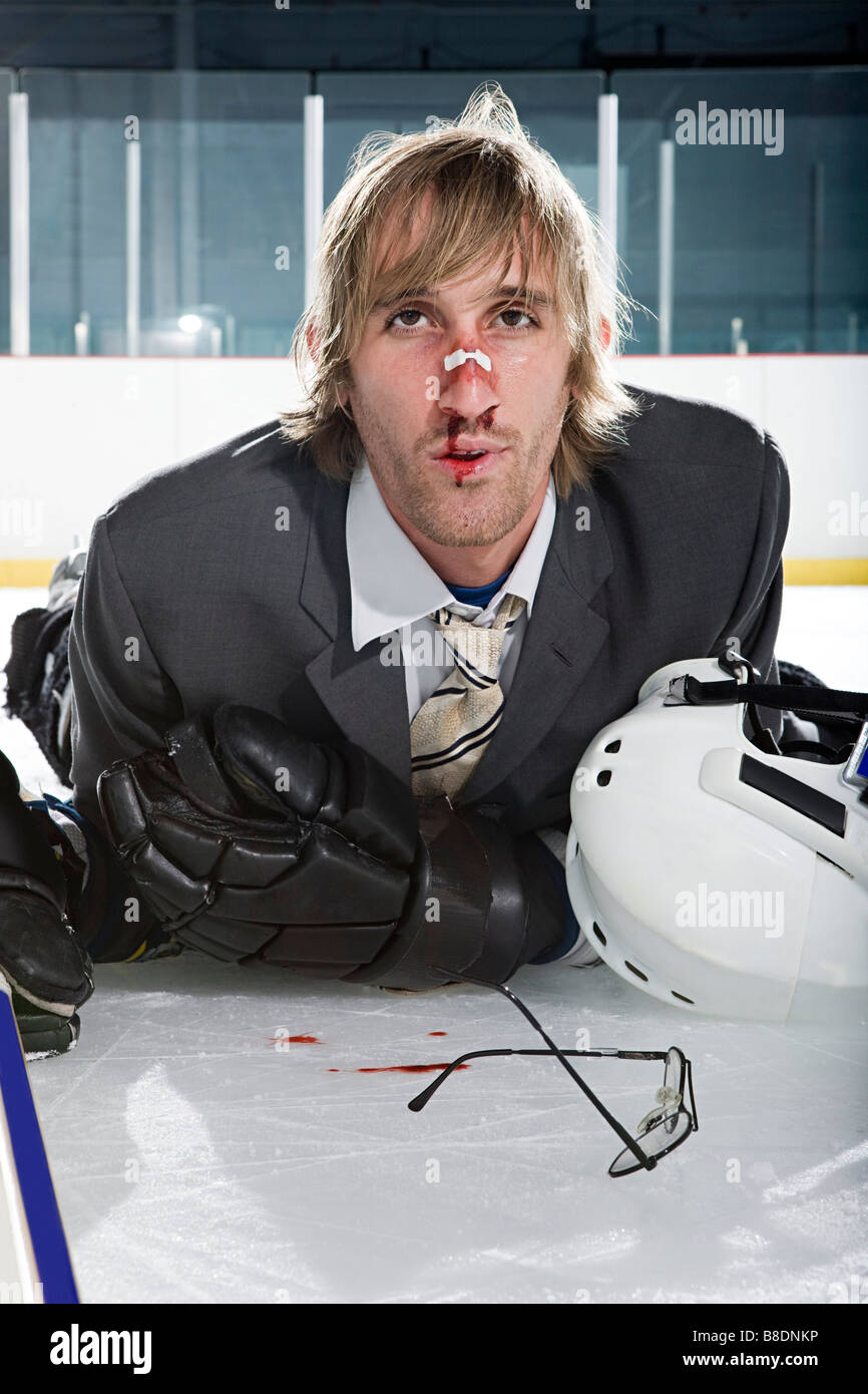 Injured businessman playing ice hockey Stock Photo