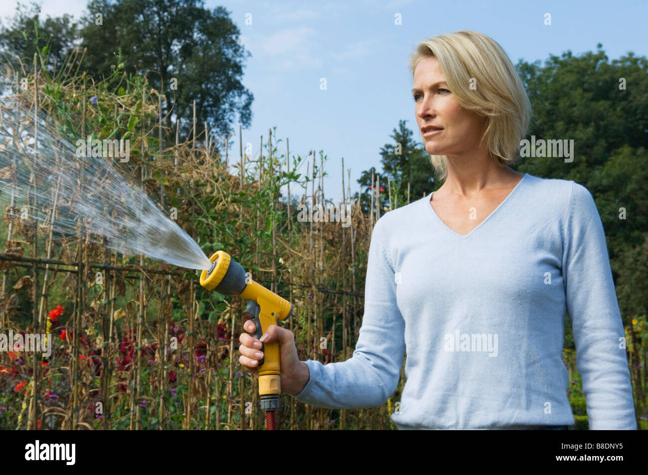Woman with hose pipe Stock Photo