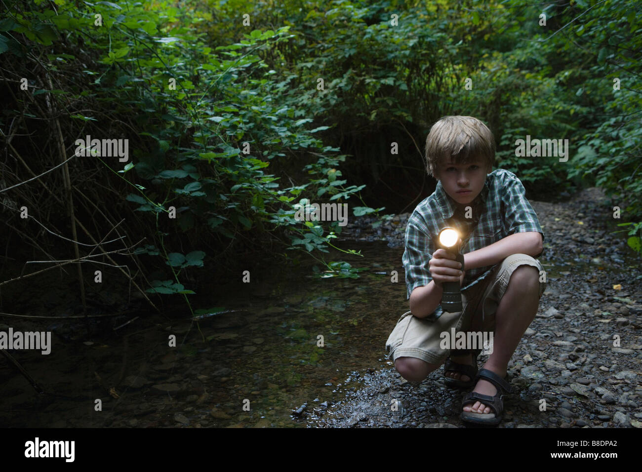 Boy with torch by river Stock Photo Alamy