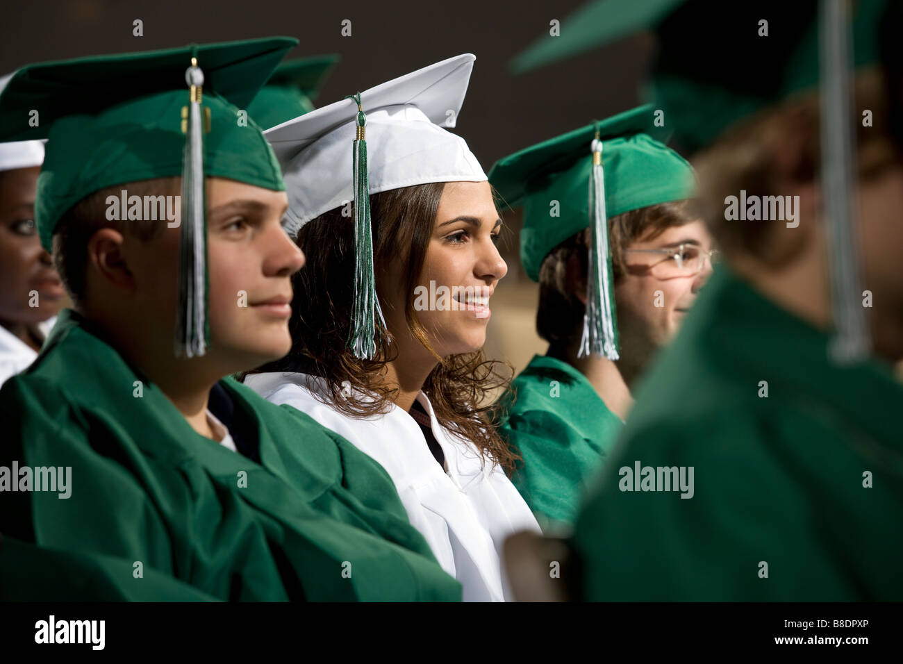 High school students in graduation gowns at commencement ceremony. Stock Photo
