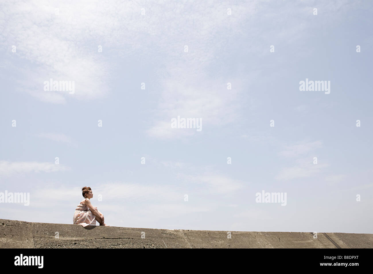 Young woman sitting wall hi-res stock photography and images - Alamy