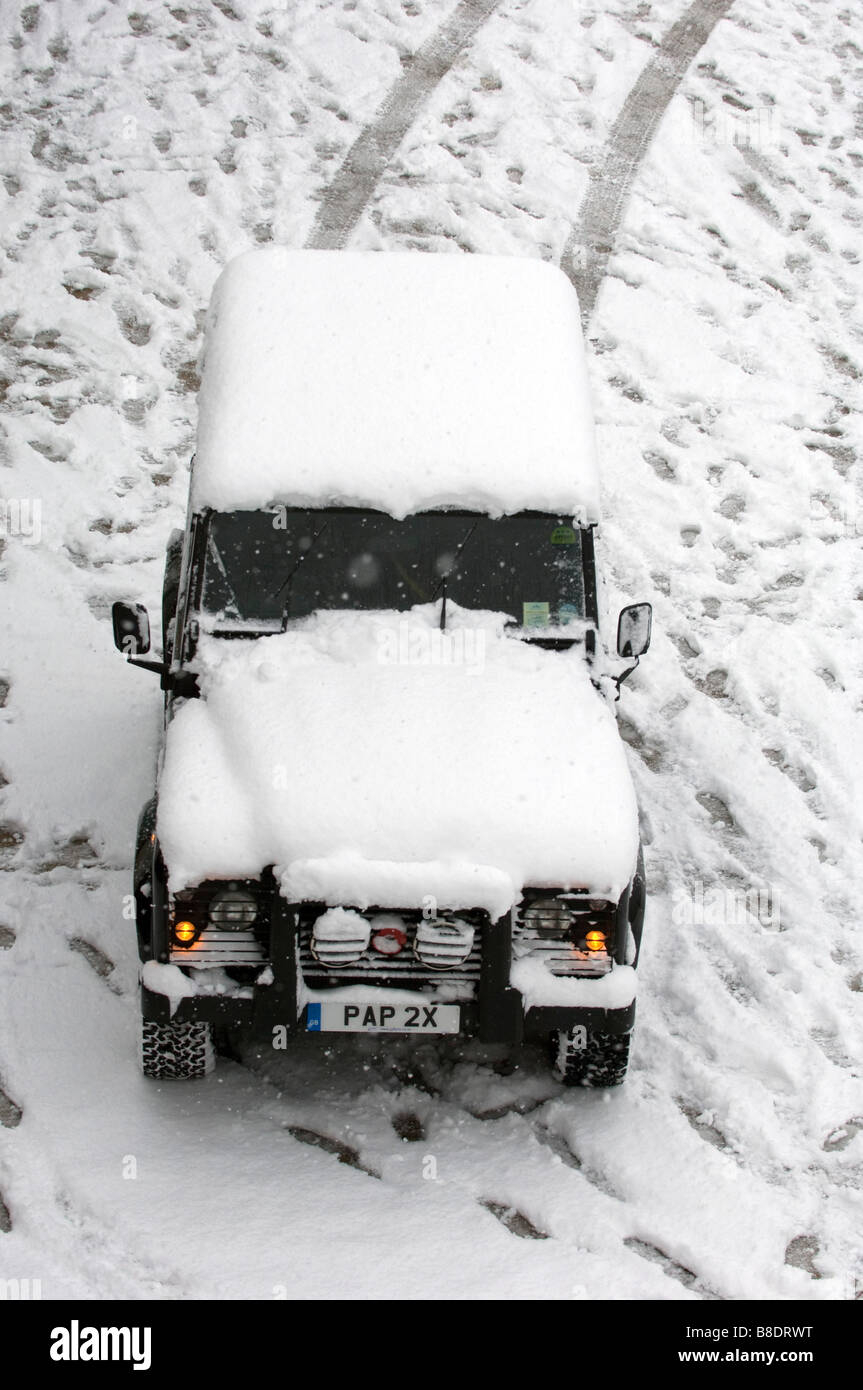 Snow covers a Land Rover Defender 90 on Brighton beach East Sussex UK Stock Photo