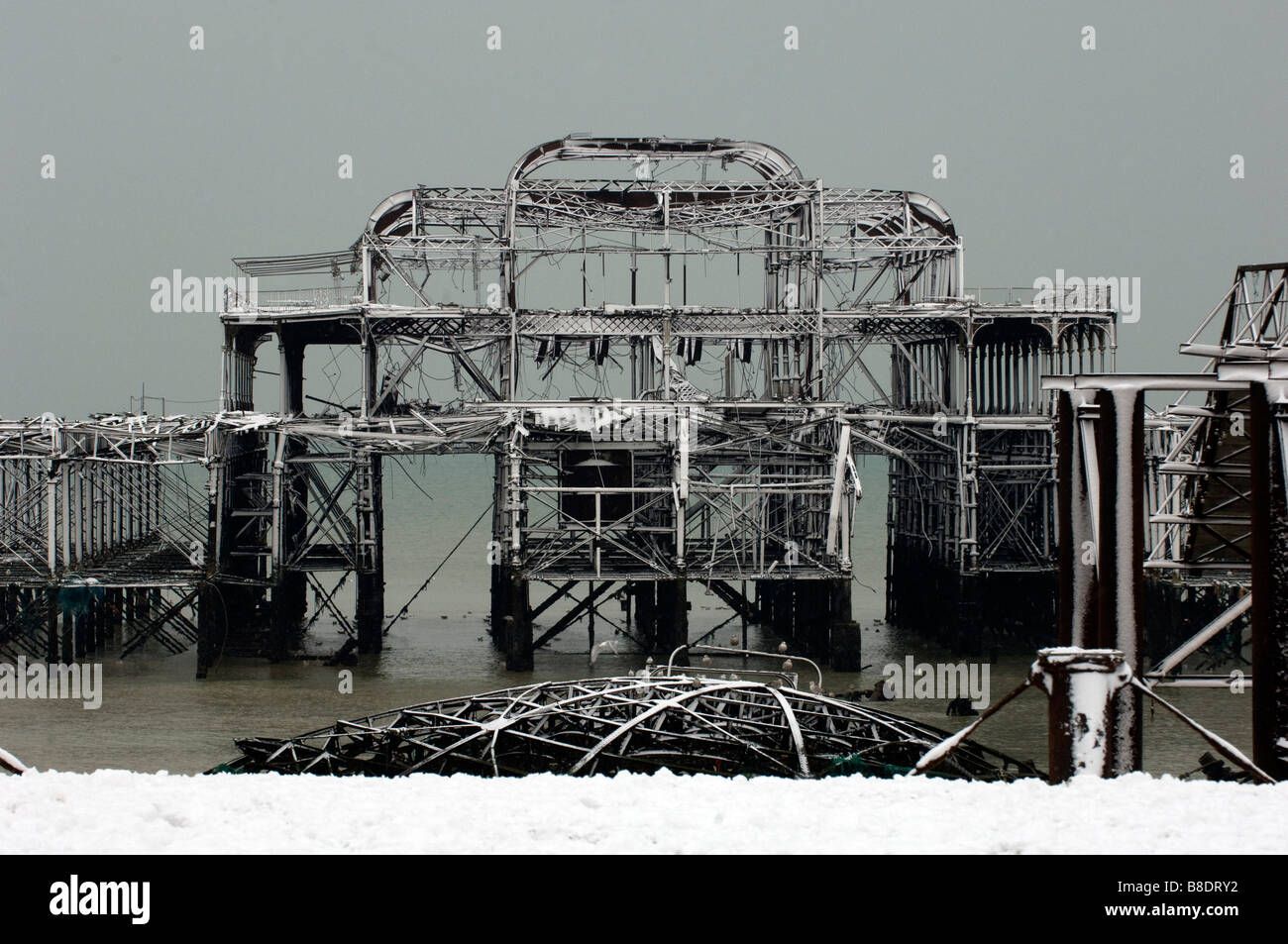 Snow covers the ruin of the West Pier off Brighton Beach, Sussex, on a winters day. Stock Photo