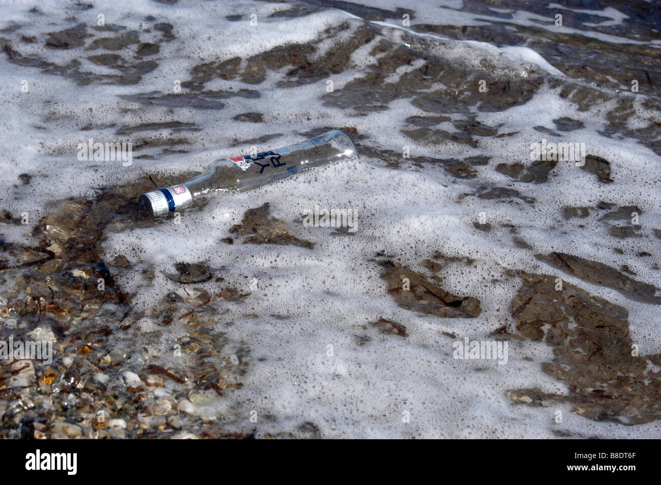 Empty botlle of Raki floating in the sea Stock Photo