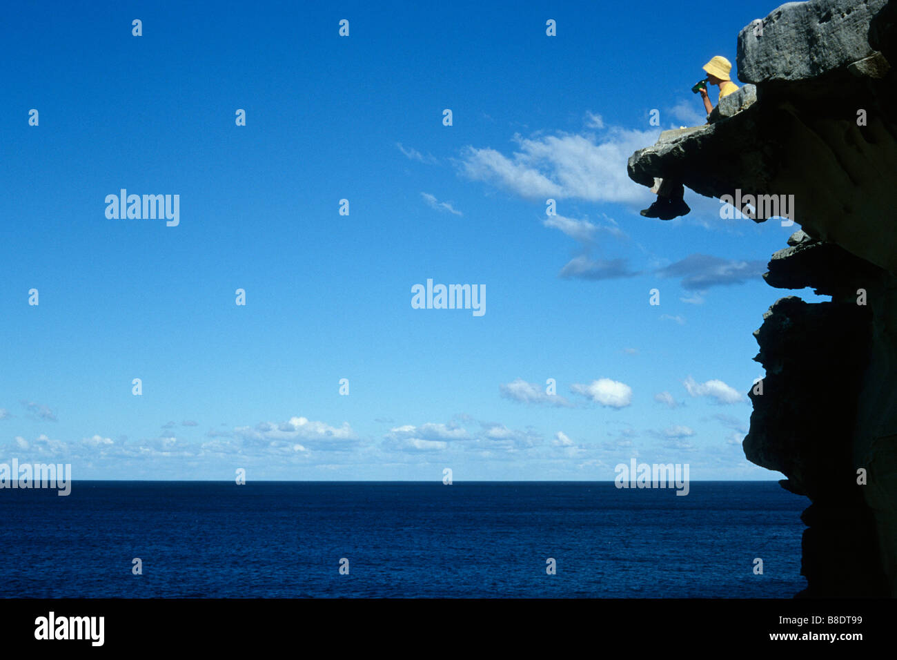 Sydney Australia A traveller sat on cliffs Bronte Beach Stock Photo