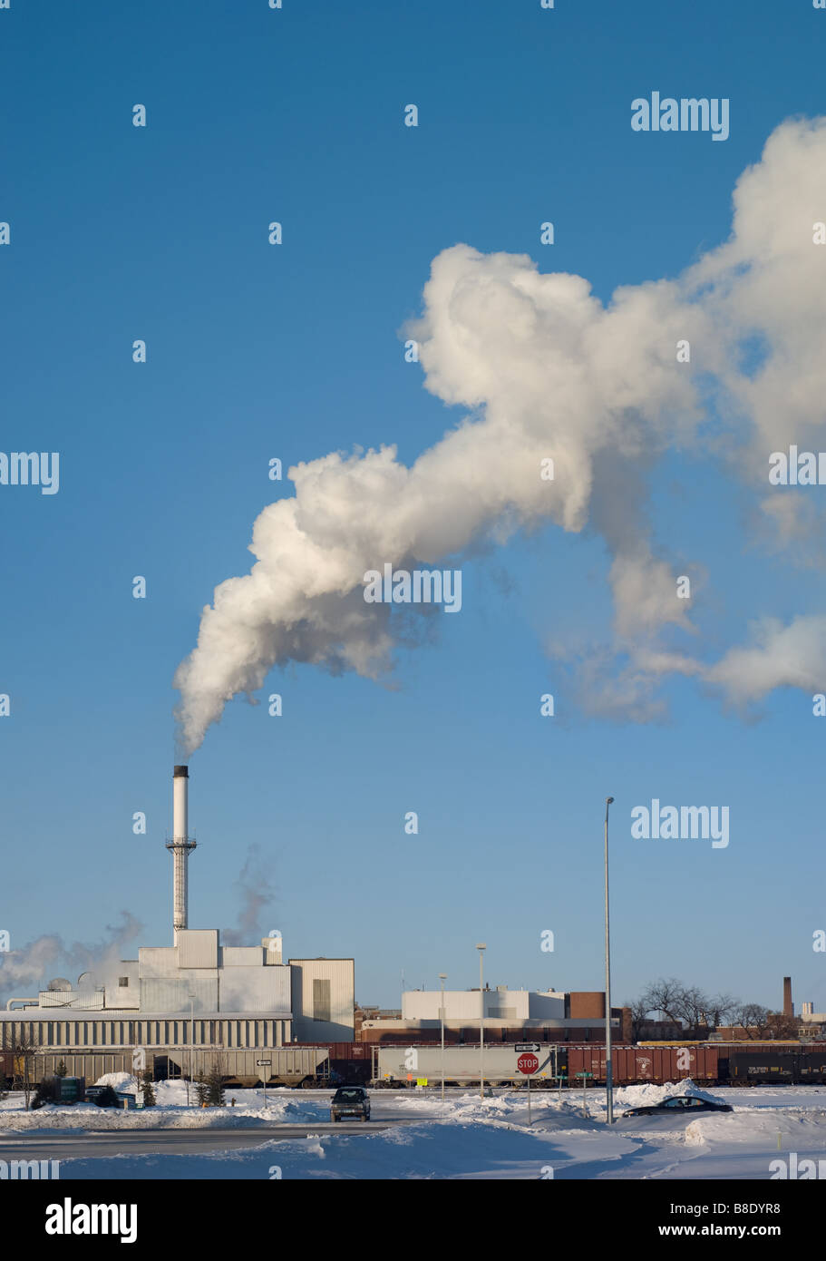 Factory smokestack billows steam on clear cold day Stock Photo Alamy