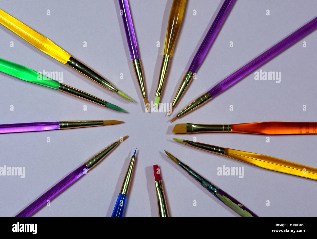 Brightly Colored Paint Brushes in Starburst Shape on Neutral Background