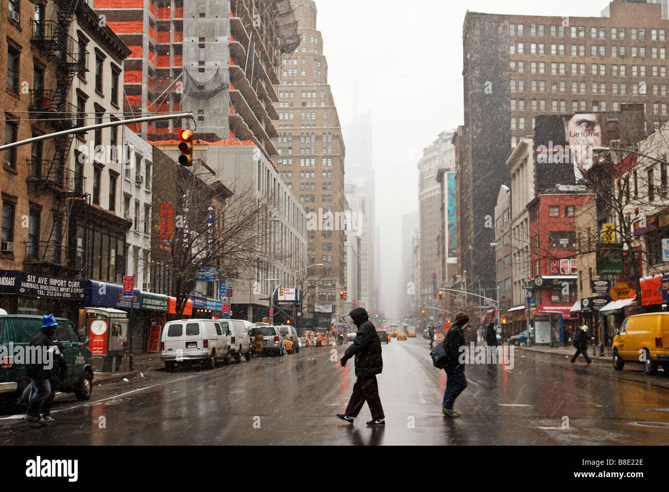 New York City pedestrians braving the weather as the city begins to disappear with the new snow. Stock Photo