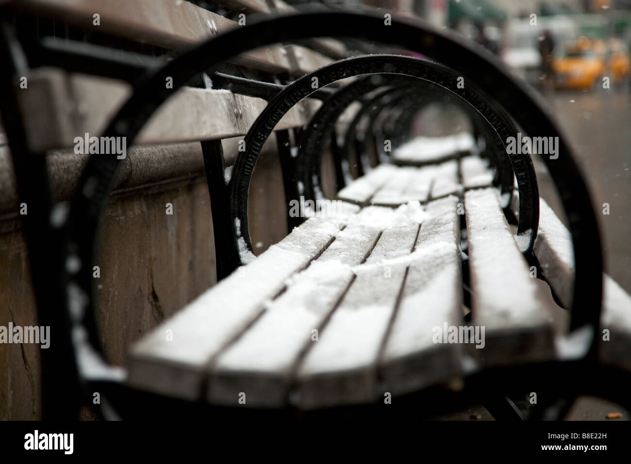 A New York City park bench covered in snow at Union Square. Stock Photo