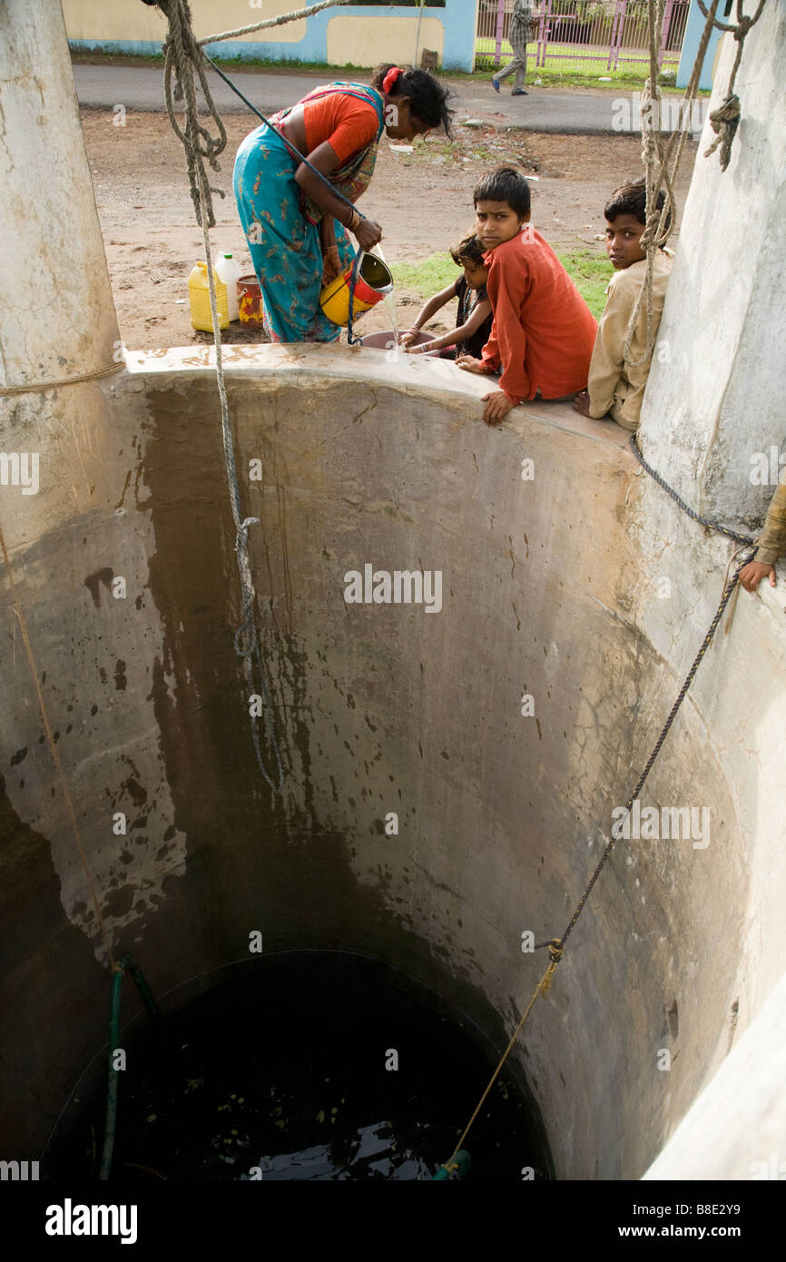 Women using a bucket to draw water from a well. Hazira, Surat, Gujarat. India Stock Photo Alamy