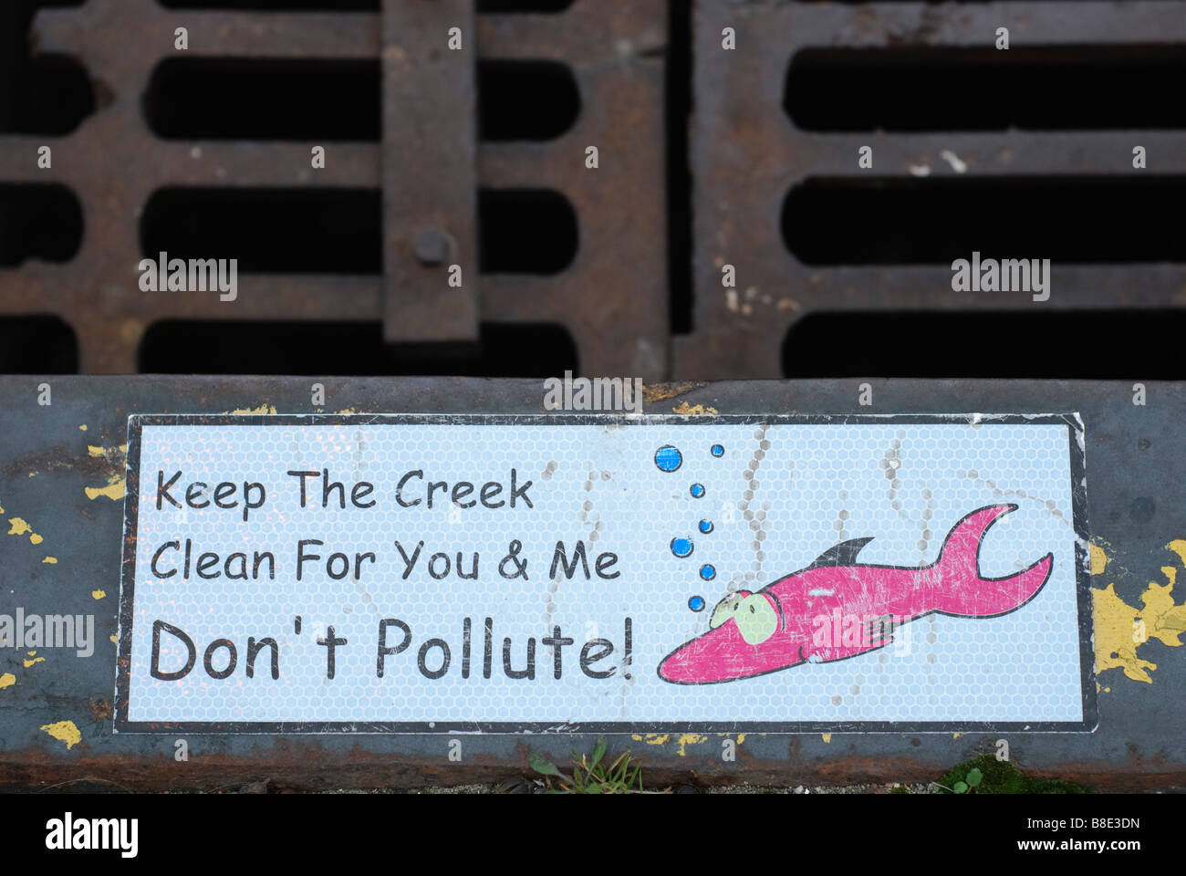 Sign with a fish and don not pollute the water sign at a drain in downtown Durham Stock Photo