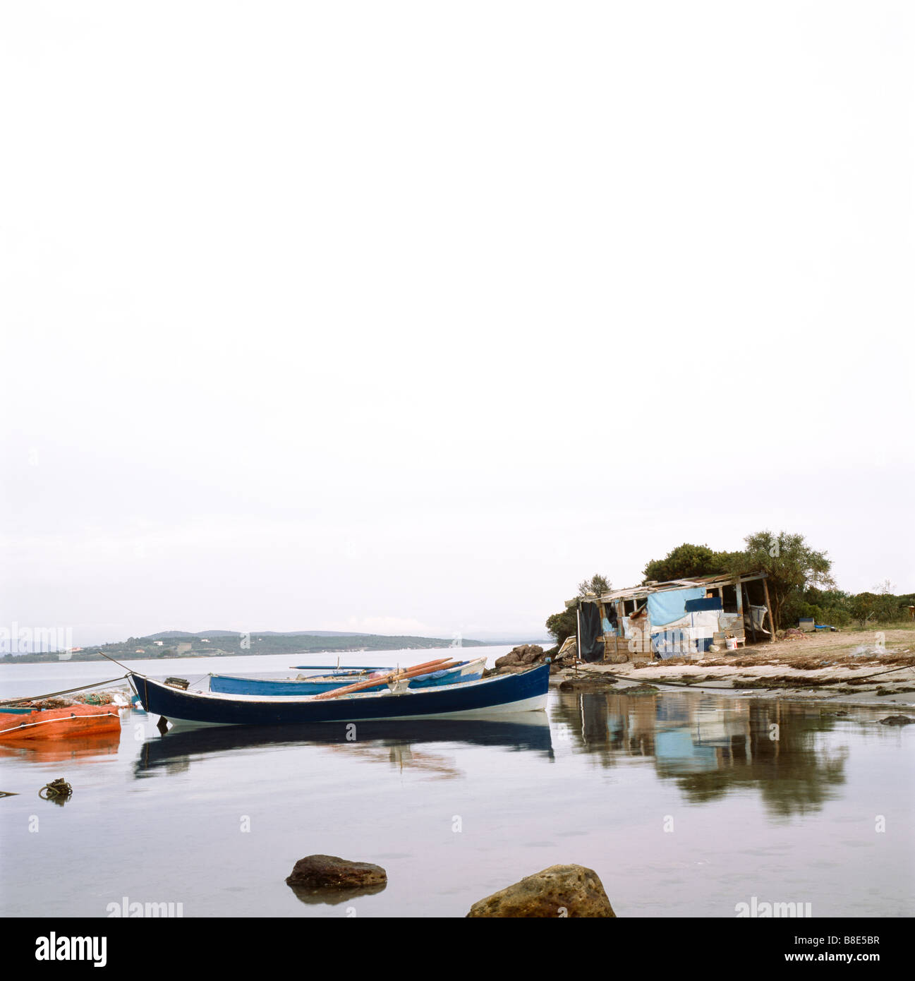 fisherman boat mored in front of a hut Stock Photo