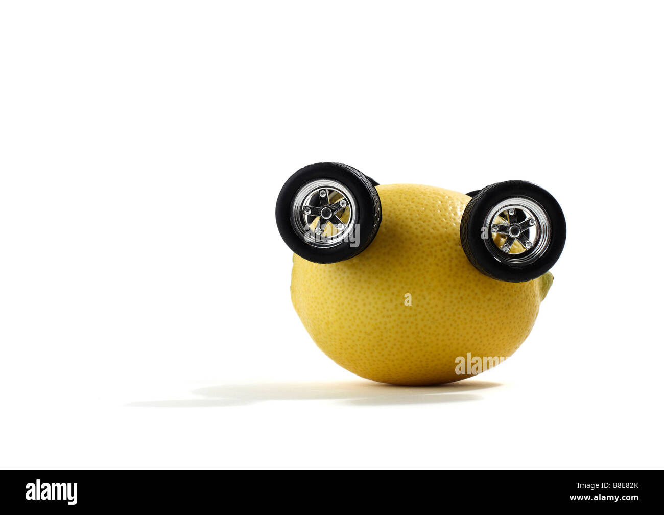 Studio shot of a whole lemon with automobile wheels turned upside down Stock Photo
